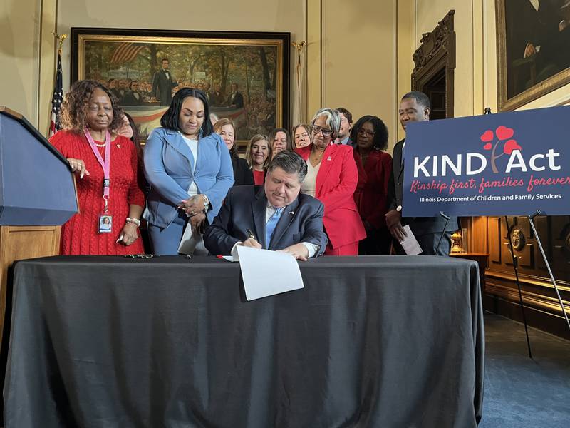 Gov. JB Pritzker signs the KIND Act Wednesday, Feb. 5, 2025, at the Illinois Capitol. The new law requires the state to prioritize family members when placing children in foster care.