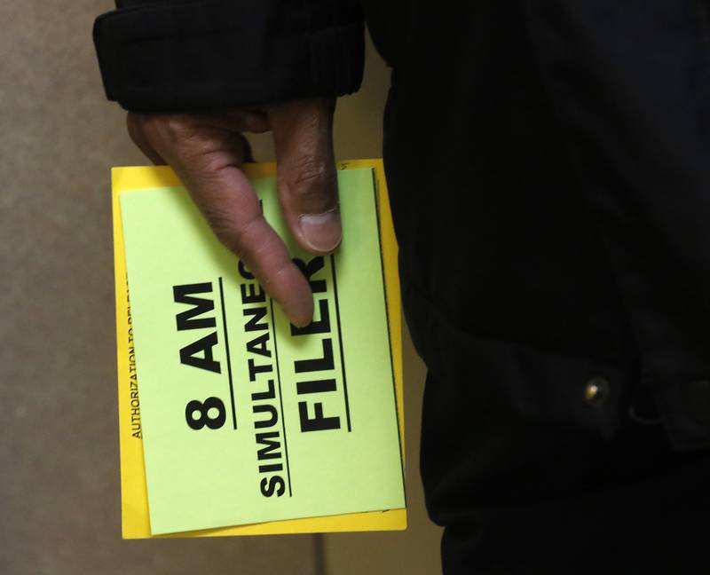 A candidate holds an “8 AM” cards at the McHenry County Clerk's Office in Woodstock on Monday, Oct. 27, 2025, the first day to file paperwork to run in the 2026 primary election. Those in line at 8 a.m. get to be first on the ballot, or in a drawing for first place if more than one candidate makes the deadline.