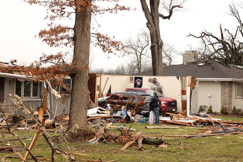 Emily LaVoie hugs a friend in the front yard as they take in the damage to the home where she lives with her husband Dave Herberger along Elmwood Drive in Aroma Township on Wednesday, March 11, 2026, following the March 10 tornado in Kankakee County.