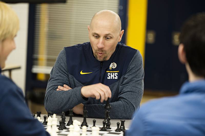 Sterling High School chess instructor Joel Penne plays a team chess game with some of his students during an off season activity hour at the school.