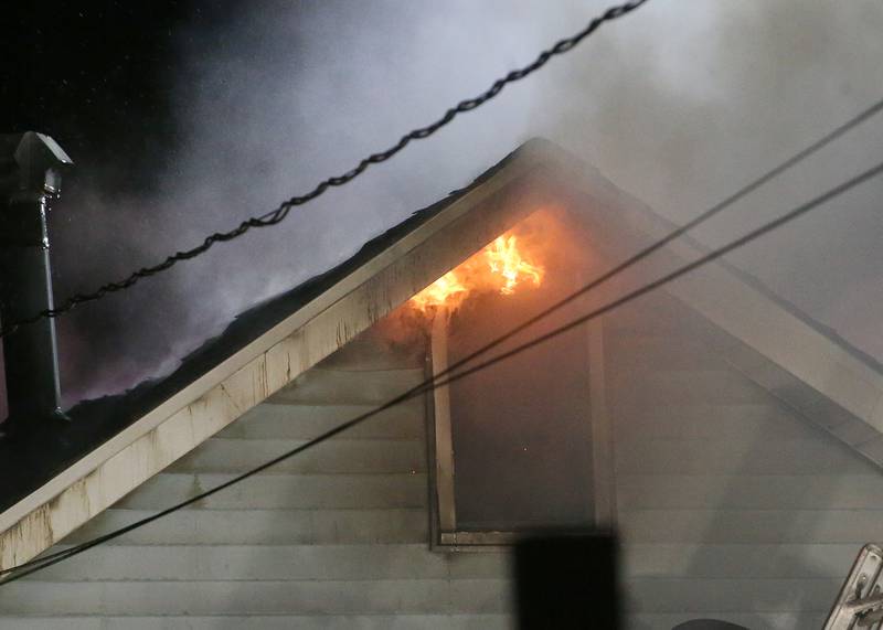 Flames emit from an upstairs window of a structure fire in the 100 block of West Cleveland Street on Thursday, May 15, 2025 in Spring Valley. The fire broke out shortly before 8:30p.m. Fire departments from La Salle Bureau and Putnam Counties responded to the scene. A mutual aid box alarm system (MABAS) call was issued prompting the response.