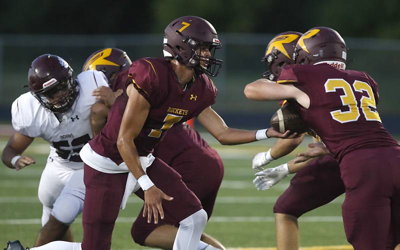 Richmond-Burton's Joe Miller hands the ball to his teammate, Steven Siegel, during a Kishwaukee River Conference football game Friday, Sept. 9, 2022, between Richmond-Burton and Marengo at Richmond-Burton Community High School.