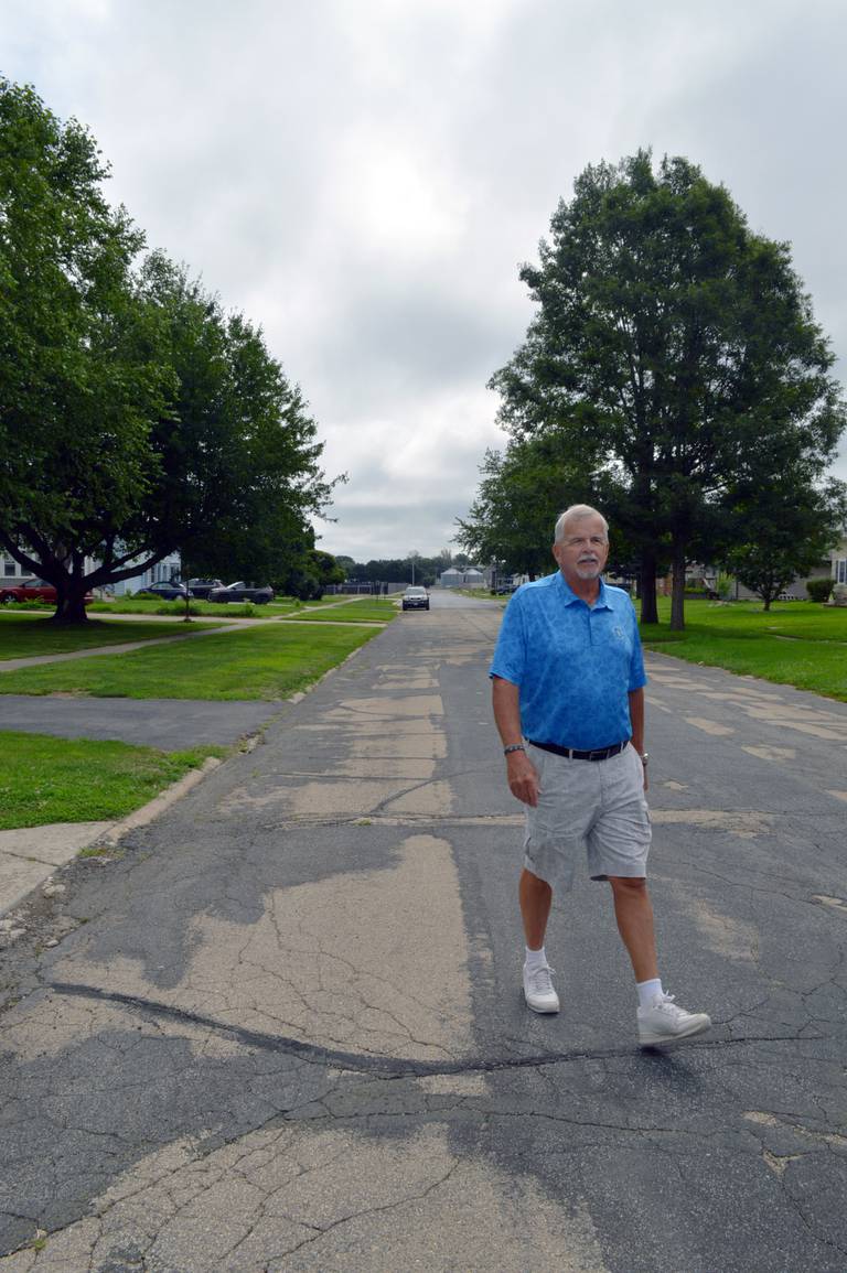 Mt. Morris Village Board Trustee Ed Higley, who is in charge of the streets, walks through the middle of Sunset Lane on Friday, Aug. 2, 2024. The Sunset Lane Project involves reconstructing the entire 5.5-block street, but is on pause this year while village officials review project financing options. Two blocks have been redone so far.
