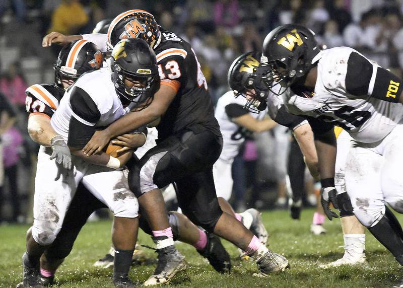 Minooka's Adrian Paige wraps up Joliet West running back Kendrick Roach during last week's game. The Indians won, 31-7, to improve to 6-1 and delay the Tigers' playoff qualification for at least a week. | Larry W. Kane for Shaw Media