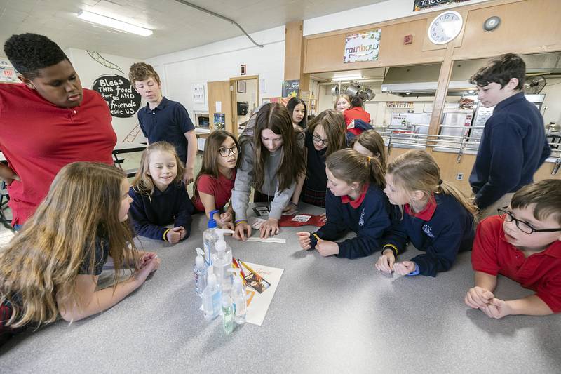 Junior high and elementary students alike work together to solve clues for the St. Mary School scavenger hunt in Dixon on Wednesday, Feb. 1, 2023.