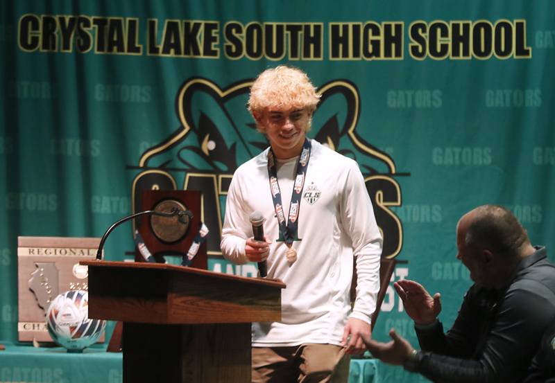 Crystal Lake South Head Coach Brian Allen claps for Nico Velasco after he talked about their season and team during a celebration for the Crystal Lake South boys soccer team on Wednesday, Nov. 8, 2023, at Crystal Lake South High School. South defeated Peoria Notre Dame to win their second soccer state championship on Saturday.