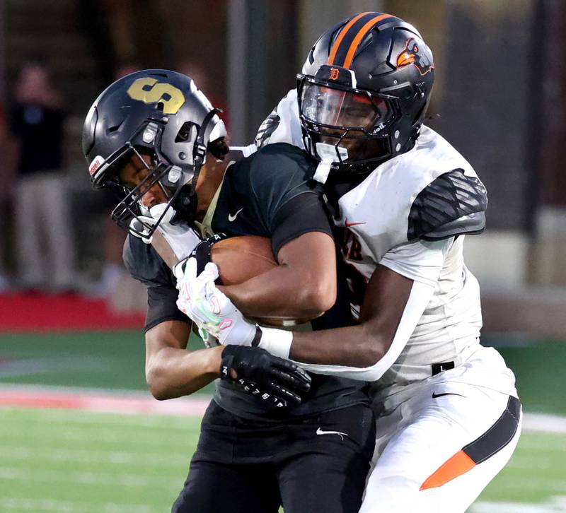 Sycamore's Dylan Curtis is brought down by DeKalb's Davon Grant Friday, Aug. 29, 2025, during the FNBO Challenge in Huskie Stadium at Northern Illinois University.