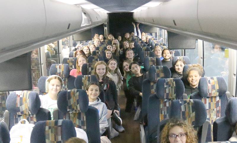 Members of the JFK seventh-grade girls basketball team pose for a photo on the charter bus before heading to the State Championship game on Thursday, Dec. 12, 2024 at JFK School in Spring Valley. The Wildcats will face Mt. Sterling Brown County in the IESA Class 2A State Championship.