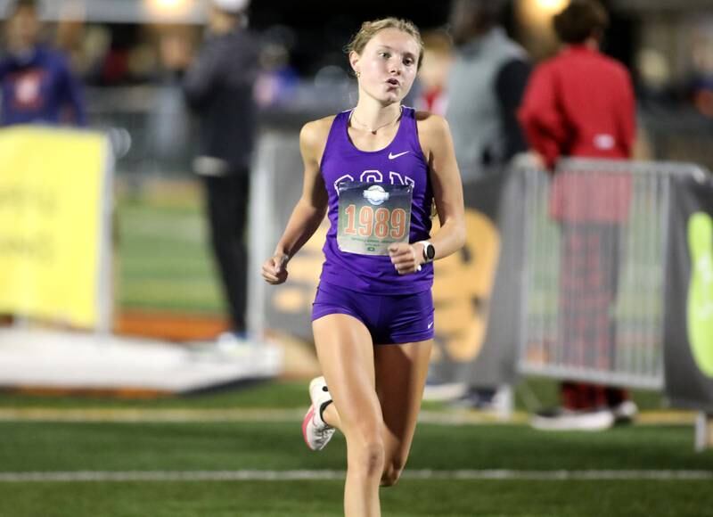 Downers Grove North’s McKenzie Willard runs to the finish in the varsity girls race during the Naperville North Twilight Cross Country Invitational on Wednesday, Oct. 9, 2024 in Naperville.