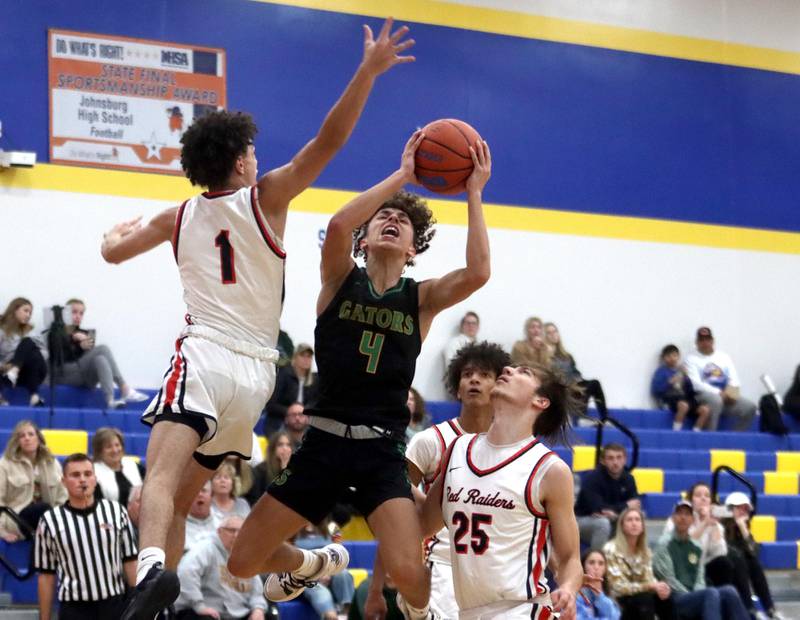 Crystal Lake South’s AJ Demirov, center, soars to the hoop as Huntley’s Lucas Crosby, left, defends during the title game of the Johnsburg Thanksgiving tournament in boys basketball on Friday.