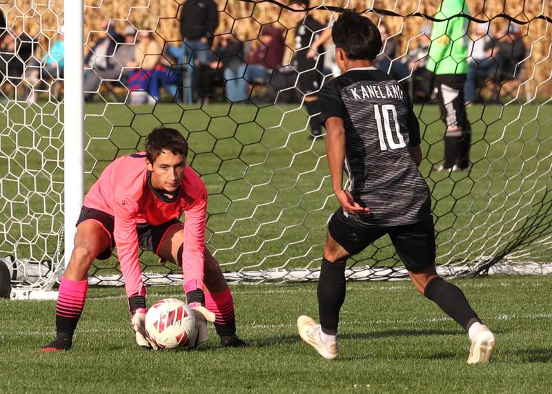 Sycamore's Connor Busch makes the save as Kaneland's Jovani Ruiz looks for a rebound during their game Monday, Oct. 7, 2024, at Kaneland High School in Maple Park.
