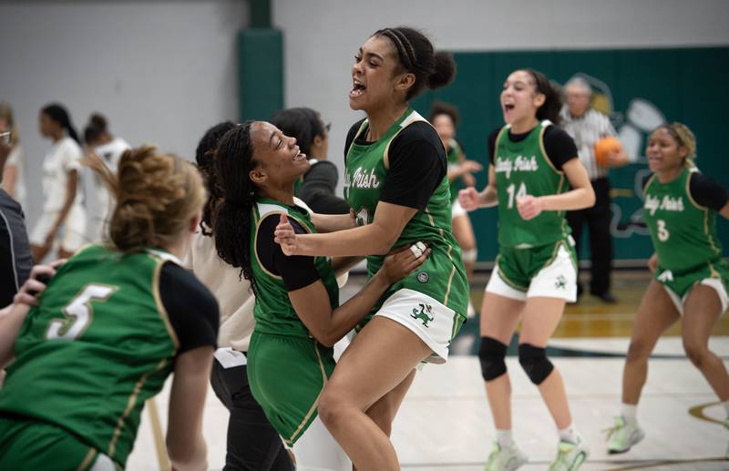 Bishop McNamara's Hailey Jackson, center left, and Kaneyce Davis, center right, celebrate after defeating Joliet Catholic in the Class 2A Regional Championship on Thursday, Feb. 19, 2026.