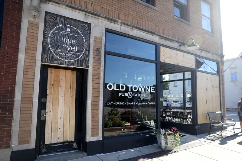 Multiple windows are boarded at the Old Towne Pub on State Street in Geneva.