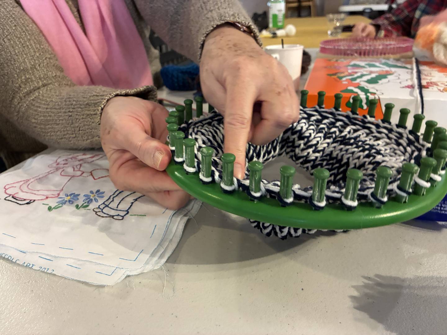 Using a loom, seen here on Thursday, Dec.  4, 2025, the women who craft at the McHenry Moose Lodge can make a new winter hat in less than two hours.