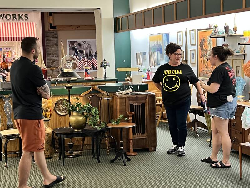 Out of the Box owner Lynn Berge shows customers around during the grand opening of the store Friday.