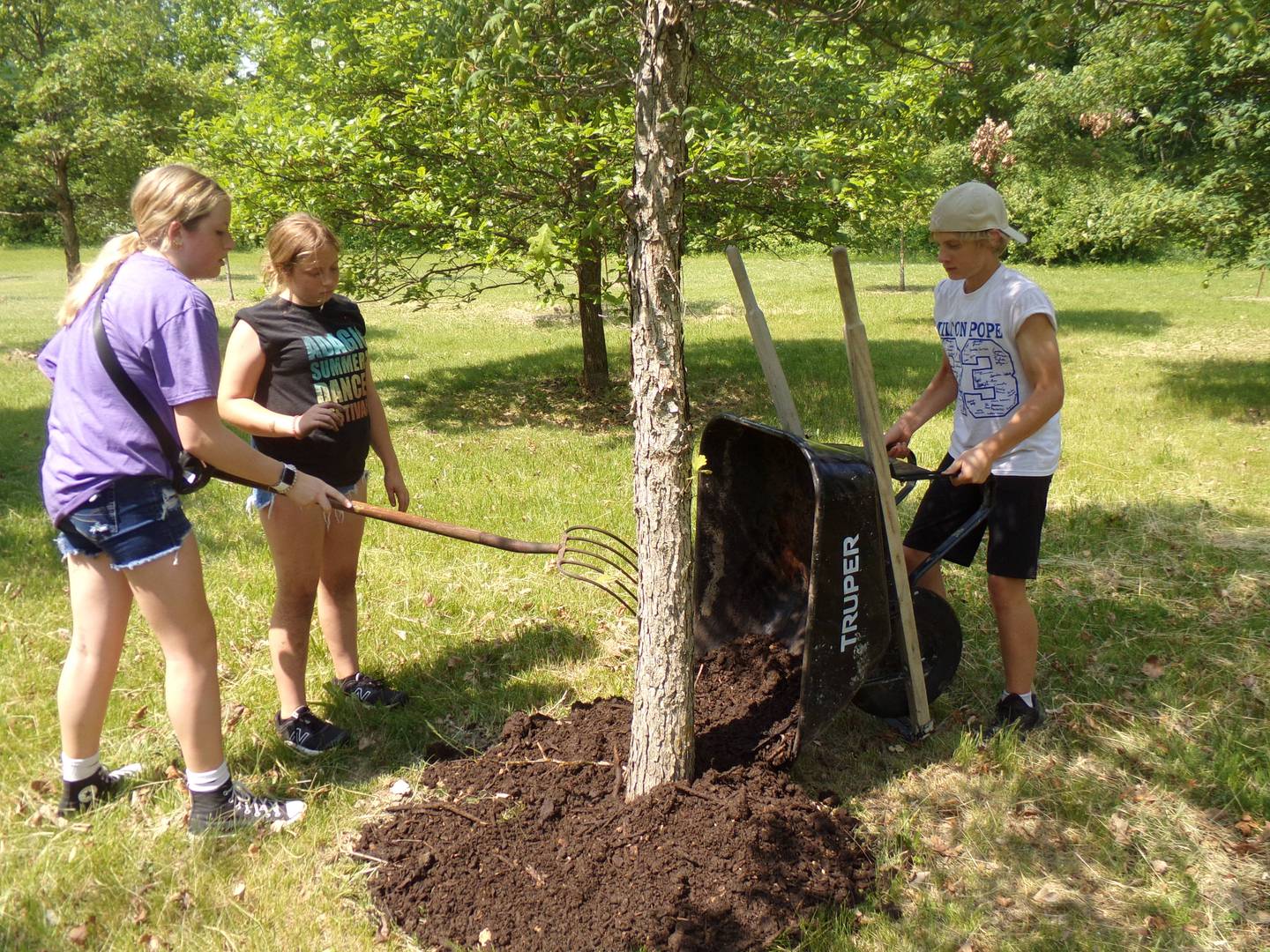 Milton Pope eighth grader Landon Brandt dumps a wheel barrow full of mulch Wednesday, May 24, 2023, for his classmates to spread at the Illinois Fallen Soldiers Tree Memorial at Illini State Park in Marseilles.