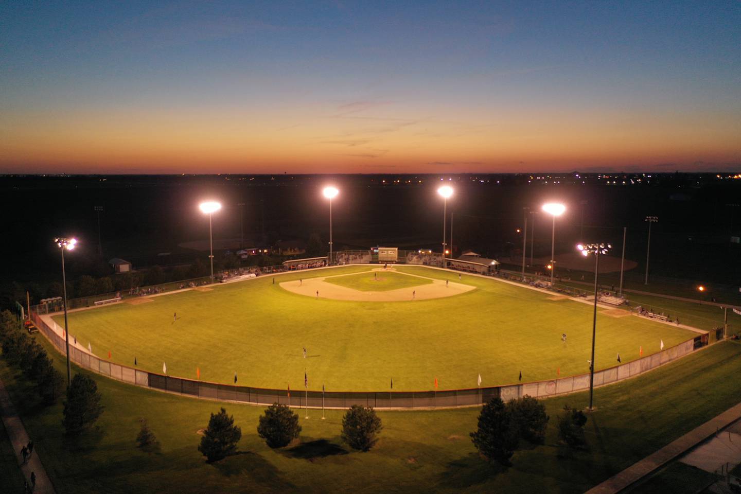 The sun sets during the Illinois Valley Pistol Shrimp's home opener against Rex Baseball on Thursday, June 2, 2022 at Veterans Park in Peru.