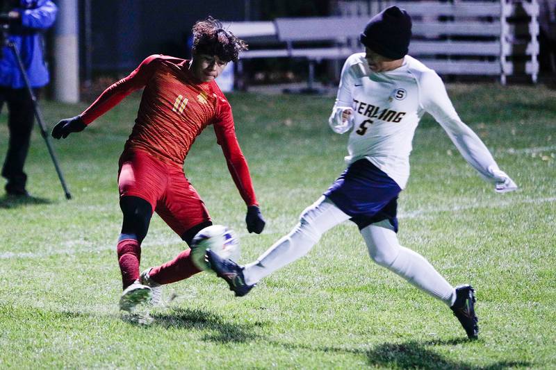 Rock Island's Omar Sosa (11) kicks the ball against Sterling's Luis Moreno (5) during the first half of an IHSA class 2a boys soccer match, Tuesday, Oct. 18, 2022, in Geneseo.