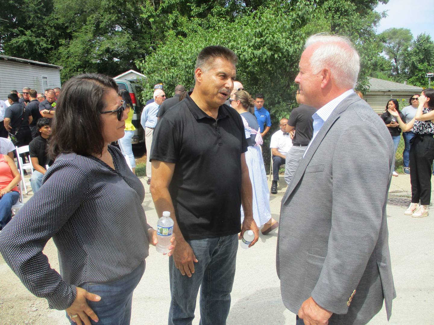 Joliet Mayor Terry D'Arcy talks with Jose Duenez  Jr.'s parents, Jose Duenez Sr. and Leticia Quintero, before a street dedication honoring their son, Jose Duenez Jr., on Friday. July 11, 2023