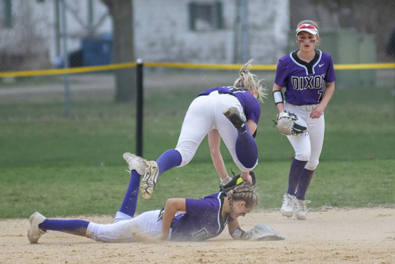Dixon's Izzi McCommons flips over a teammate while trying to field a pop fly Tuesday, April 12, 2022 against Rock Falls.