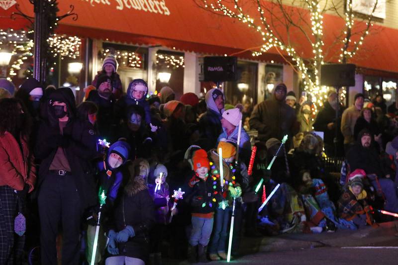 Children line the streets as they eagerly await a glimpse of Santa and Mrs. Claus during the annual Festival of Lights Parade on Friday, Nov. 26, 2021, in downtown Crystal Lake.