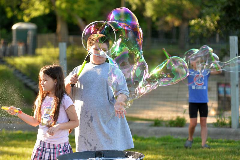 Bishop and Kairi Comins, 11 and 7, of Oregon, make some bubbles at the River's Edge Farmers Market in Oregon on Thursday, June 19, 2025. The bubble fun was provided by "Bubble Guy" Jason Kollom, who was sponsored by the Oregon Public Library. The Farmers Market is held Thursday nights 5-7:30 p.m. at 123 N. 2nd St., in Oregon.
