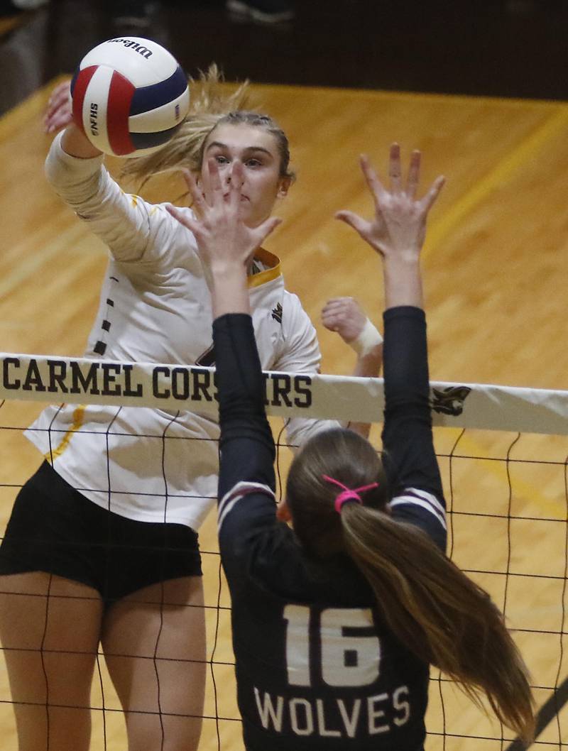 Carmel's Liv Johnson tries to hit the ball through the block of Prairie Ridge's Addy Grider during the IHSA Class 3A Carmel Sectional championship volleyball match on Thursday, Nov. 6, 2025, at Carmel High School, in Mundelein.