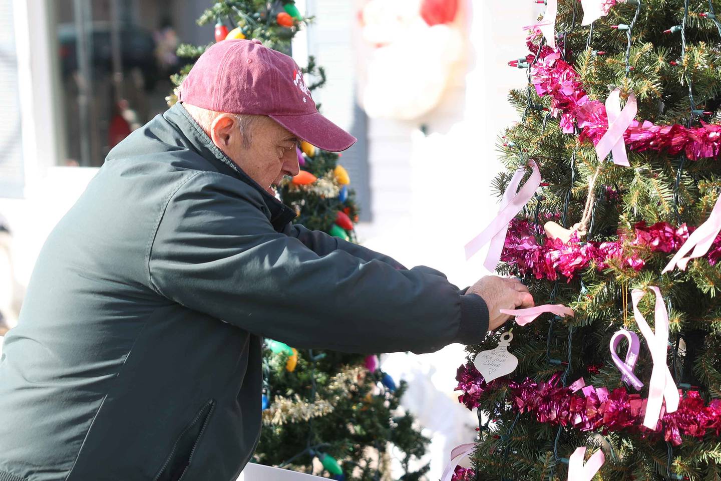 Sam Chellino adjust an ornament on the Tree of Hope in honor of those effected by cancer on Friday, Dec. 13, 2024 in Joliet.