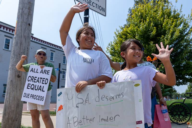 Children wave while hold signs at the “No Kings” protest on Saturday,  August 9, 2025 at Rotary Park in Princeton.
