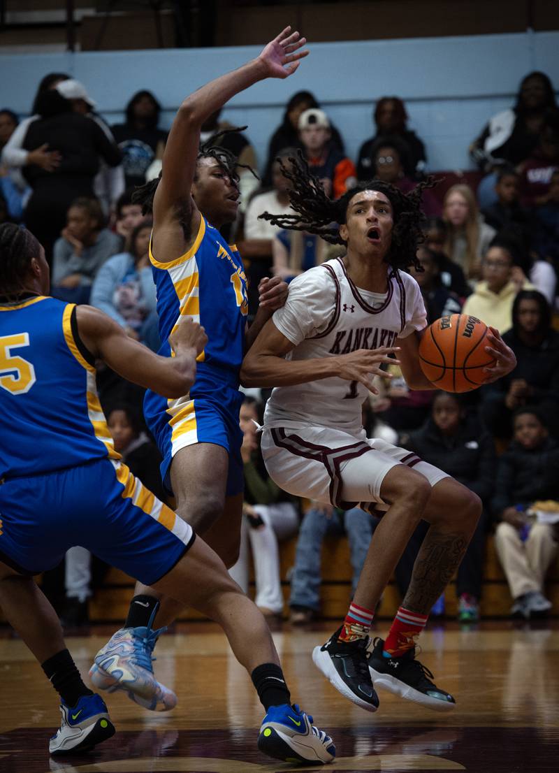 Kankakee's Lincoln Williams looks for a clear shot under the net as Crete-Monee's Kendle Cobb, left, tightly guards in a game on Friday, January 9, 2026.