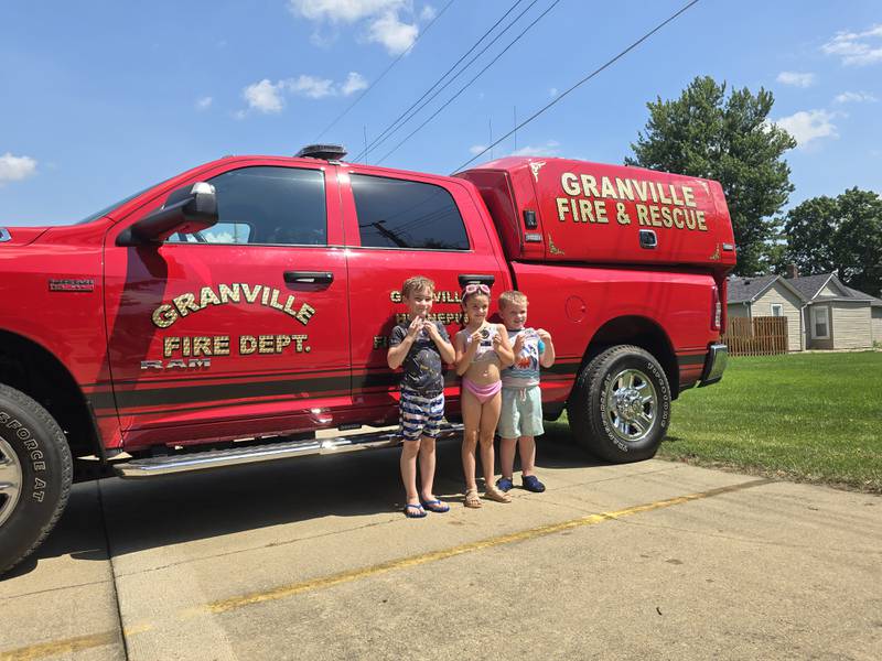 (From left) Emmett Gibson (second), Kaden Wiley (third) and Rylie Konczak (first) show off their water fight trophies Saturday, Aug. 3, 2024, during Granville Days in Hopkins Park.
