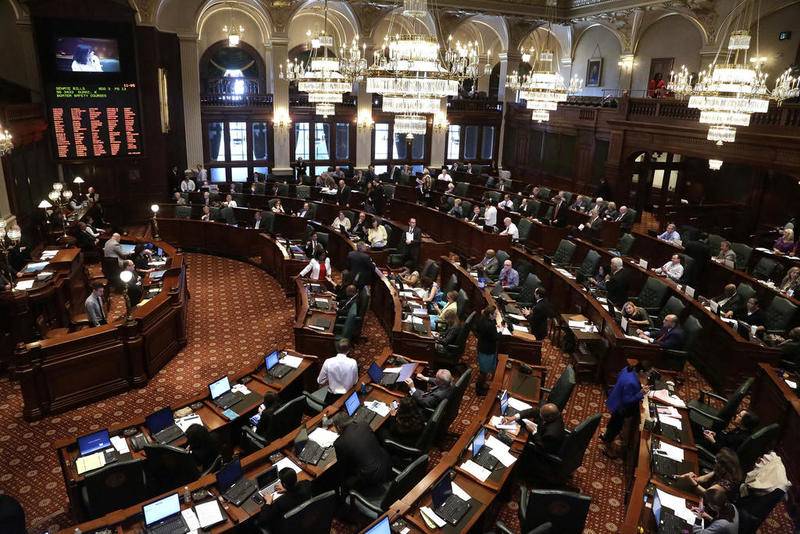 In this Friday, May 30, 2014 file photo, lawmakers are seen on the House floor during session at the Illinois State Capitol in Springfield Ill. More than two-dozen legislators, about 15 percent of the General Assembly, have either resigned months into the current session or said they won't seek re-election.