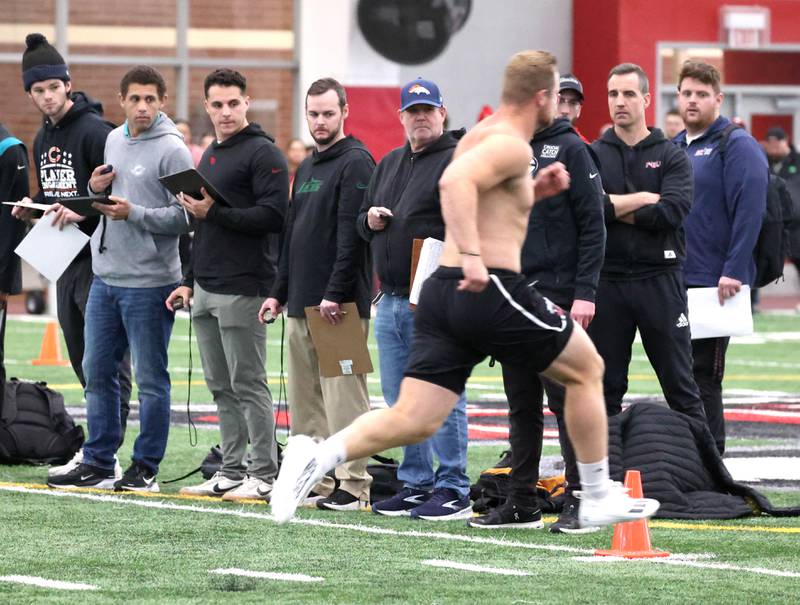 National Football League scouts from various teams watch former Northern Illinois University football players run the 40-yard dash during pro day Monday, March 17, 2025, in the Chessick Practice Center at NIU in DeKalb. Pro day gives NIU players who have used up their eligibility to perform for NFL scouts in hopes of catching on with a team.