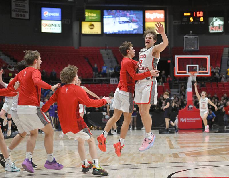 Aurora Christian High School’s Cam Morel jumps with teammates at the end of overtime and the Eagles win against Pecatonica High School in the Class 1A supersectional boys basketball game at Northern Illinois Unversity on Monday, March 4, 2024.