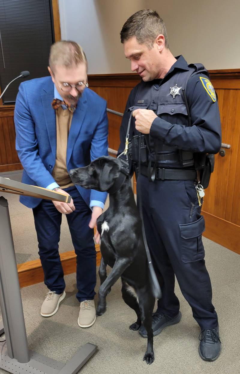 Mini Hooper, the Ottawa Police Department's newest canine officer, is sworn in by Mayor Robb Hasty while Mini's handler, officer Charlie Hooper, stands ready at the ottawa City Council meeting Tuesday.