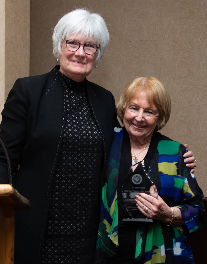 Linda Olds-Steinert (right) is presented with the 2024 UIC College of Nursing Distinguished Alumna Award by faculty member Kate Tredway.