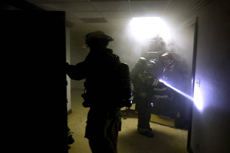 Algonquin firefighters from RIT team one  enter a smoke filled basement as they search for an injured firefighter on Tuesday April 15, 2025, during a RIT crew and chief divisional drill with other firefighters from area departments in a former bank building in Downtown McHenry.
