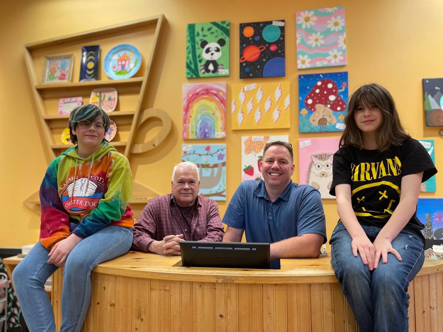U.S. Navy veteran Jason Stucky (second from right), his husband Kevin and their children Claire (right) and Casey (left), at their Color Me Mine franchise in Geneva.