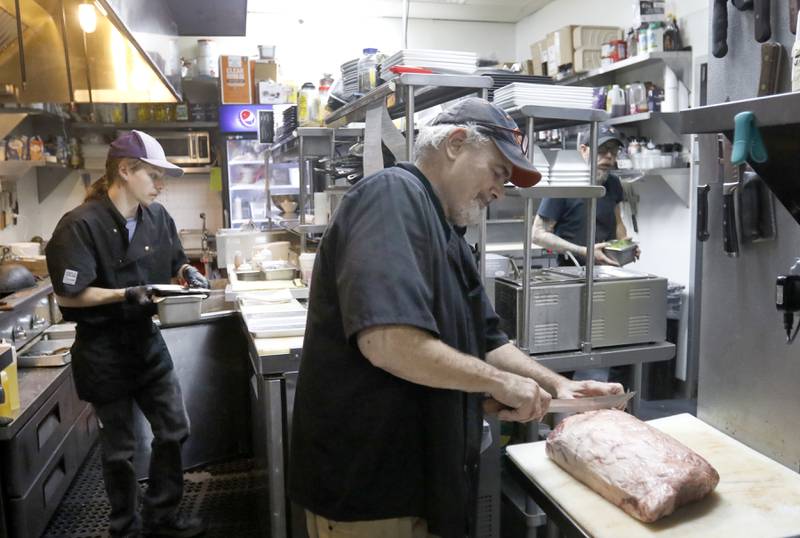 Michael Borlek, the executive chef at Addison's Steakhouse, cuts steaks as he and his sous chef Joseph Beekil, left, prepare food for the dinner service Thursday, Sept. 7, 2022, at the restaurant, 335 Front St. in McHenry. Some area restaurants are still struggling to find staff.
