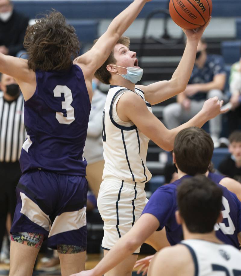 Cary-Grove's Jake Hornok looks for the basket past Hampshire defender Miles Wiggins during their game on Tuesday, January 25, 2022 at Cary-Grove High School in Cary.