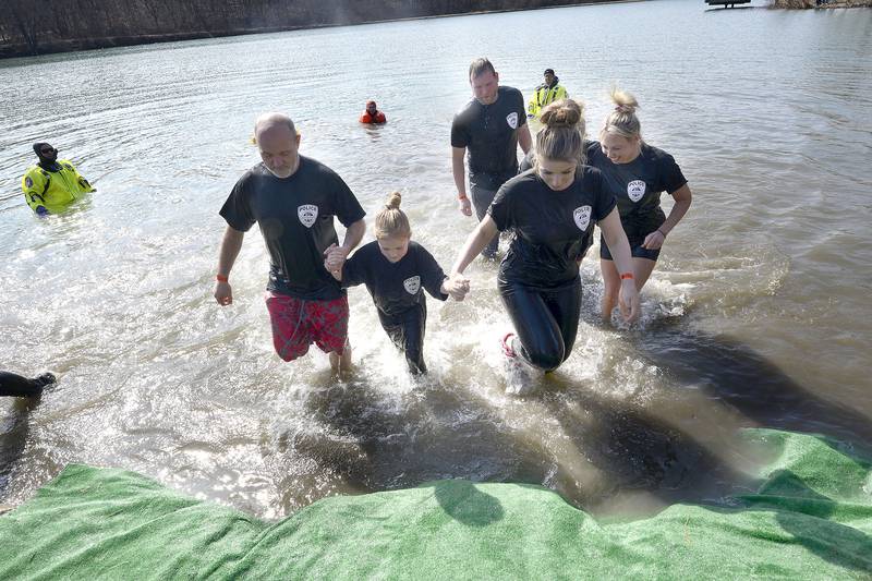 Members representing the Montgomery Police Department emerge from the lake during the annual Polar Plunge to support Special Olympics Illinois at Siver Springs State Park's Loon Lake on Sunday, Mar. 5, 2023.