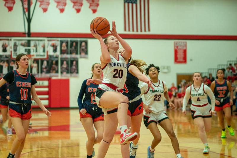 Yorkville's Ava Hendershott (20) drives to the basket against Oswego’s Ashley Cook (33) during the 13th annual Hoops 4 Hope Communities vs. Cancer basketball event at Yorkville High School on Saturday, Jan 28, 2023.