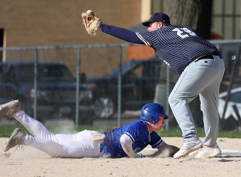 Hinckley-Big Rock's Austin Roop dives back in safely as Hiawatha’s Logan Brush has the ball almost go through the webbing on his mitt on a pickoff attempt Tuesday, April 29, 2025, during their game at Hiawatha High School in Kirkland.