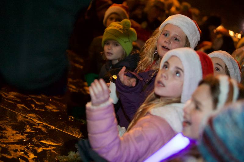 Kids wait for a piece of the first candy cane at the Geneva Christmas Walk on Friday, Dec.1 2023 in Geneva.