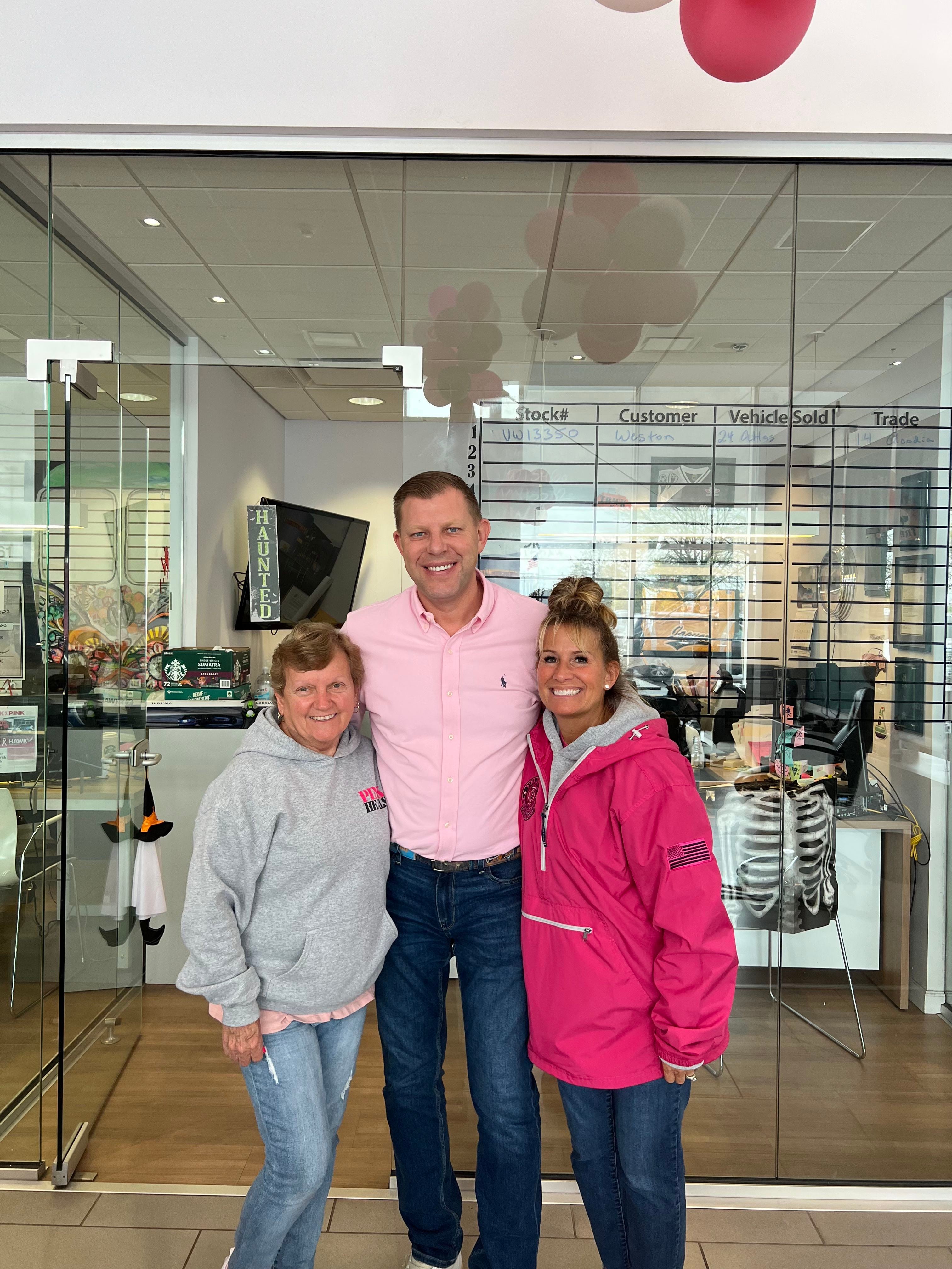 Damian Gabrus, general manager of Hawk Volkswagen in Joliet (center), with 
 Pink Heals Joliet President Angie Caldwell (right) with a person assisted by the Pink Heals organization.  The nonprofit helps local women who have breast cancer and their families.