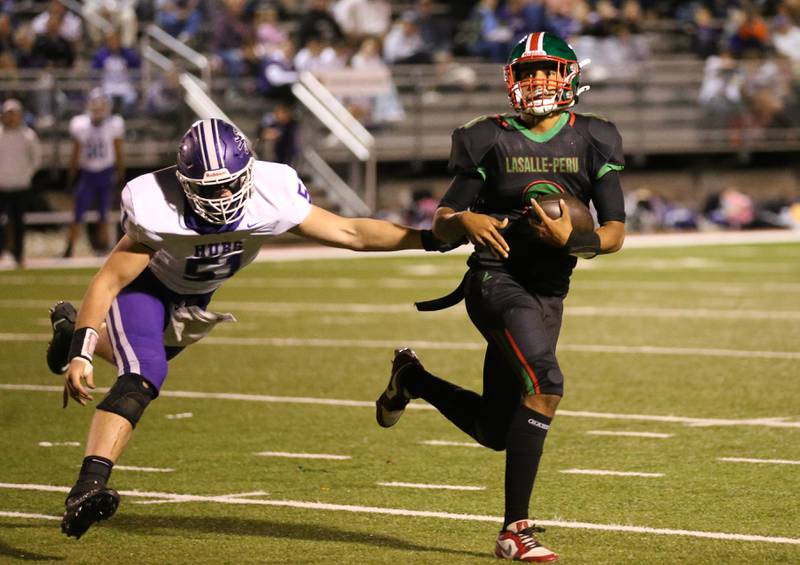 L-P quarterback Marion Persich runs the ball as Rochelle's Colton Czekala chases him out of bounce on Friday, Sept. 27, 2024 at Howard Fellows Stadium.