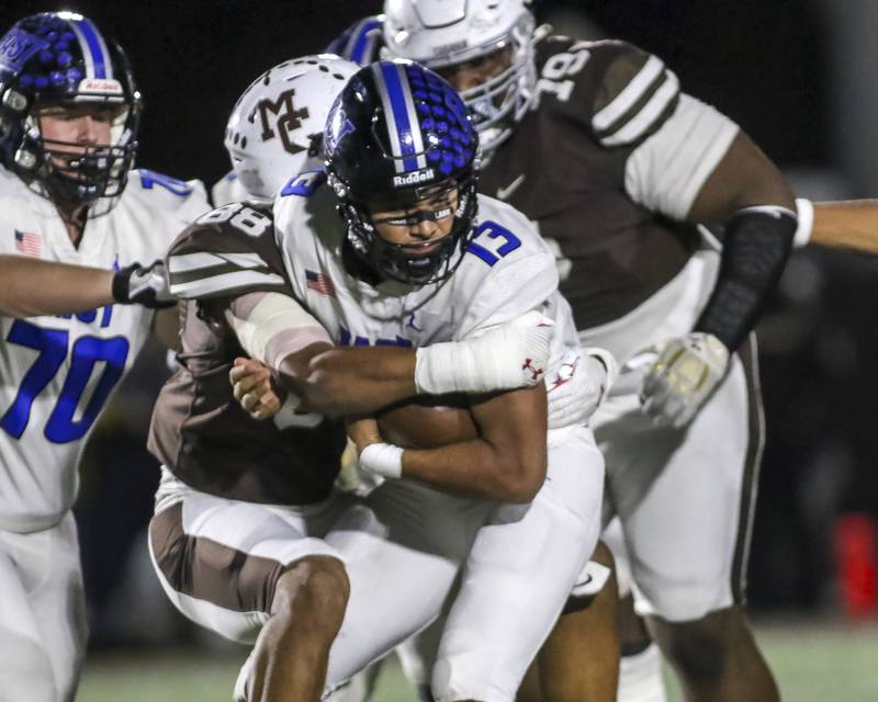 Lincoln-Way East's Jonas Williams (13) is tackled after running up the middle during Class 8A quarterfinal football game between Lincoln-Way East at Mount Carmel. Saturday, Nov 15, 2025 in Chicago.