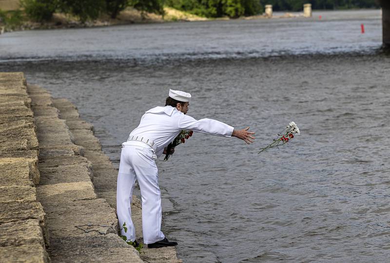 Dave Devine tosses flowers into the Rock River Monday, May 27, 2024 in Dixon to pay tribute to those who lost their lives at sea. Devine, a Dixon native, spent over 20 years in the Navy.