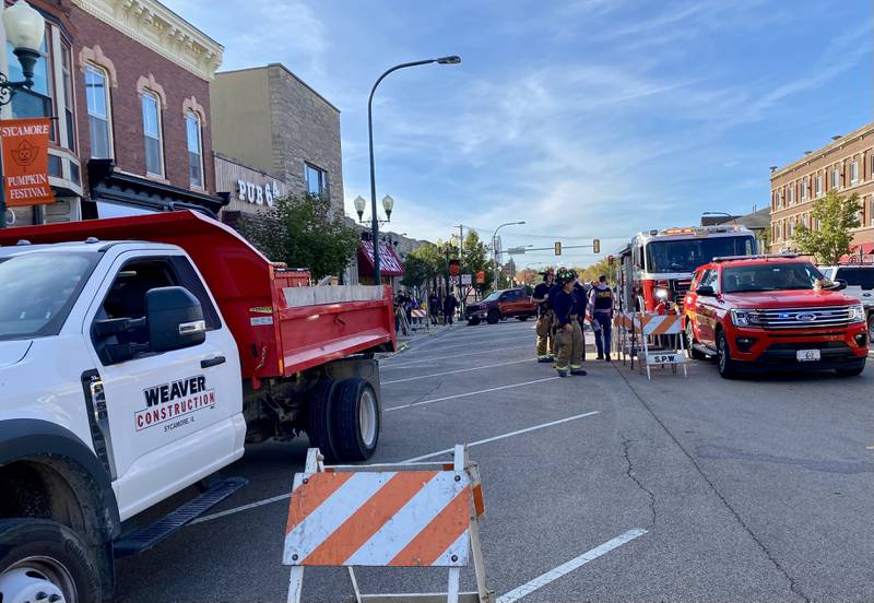 Tow vehicles removed a white SUV from the area after it crashed into the front of Atlas Roots Collective women's clothing store, 330 W. State St., on Friday afternoon, Oct. 24, 2025. Police said the crash sent a driver and passenger to the hospital with minor injuries. The area is expected to be closed to passersby through the weekend of Sycamore Pumpkin Festival.