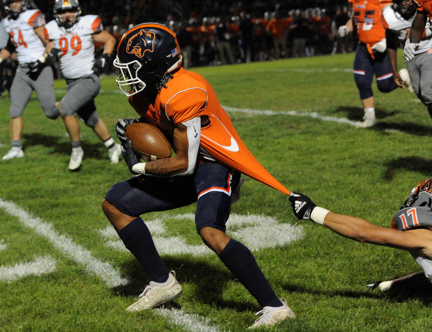 Oswego runningback Mark Melton breaks away from the jersey tug of Minooka defensive back Chase Coleman (17) during a varsity football game at Oswego High School on Friday.